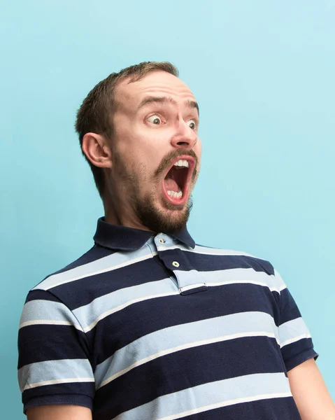 El hombre gritando con la boca abierta aislado en el fondo azul, concepto de la cara emoción — Foto de Stock