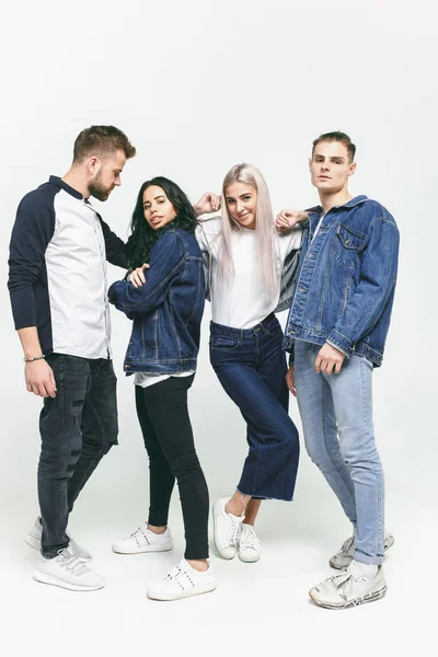 Grup gülümseyen arkadaşıyla birlikte modaya uygun kot pantolon — Stok fotoğraf