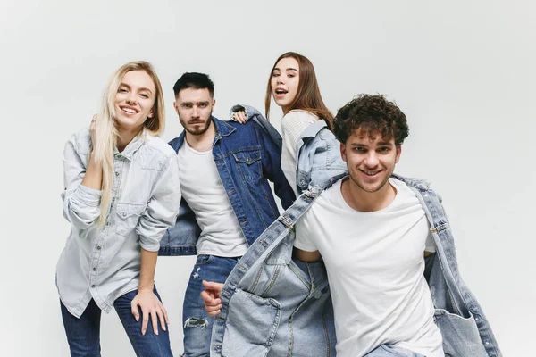 Group of smiling friends in fashionable jeans — Stock Photo, Image