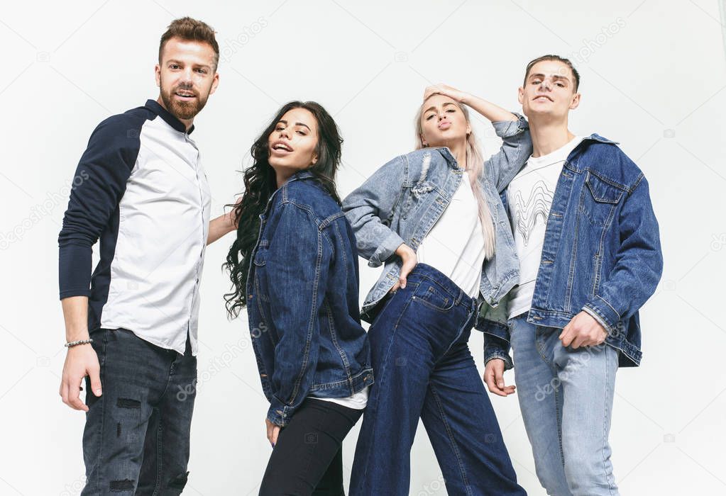 Group of smiling friends in fashionable jeans