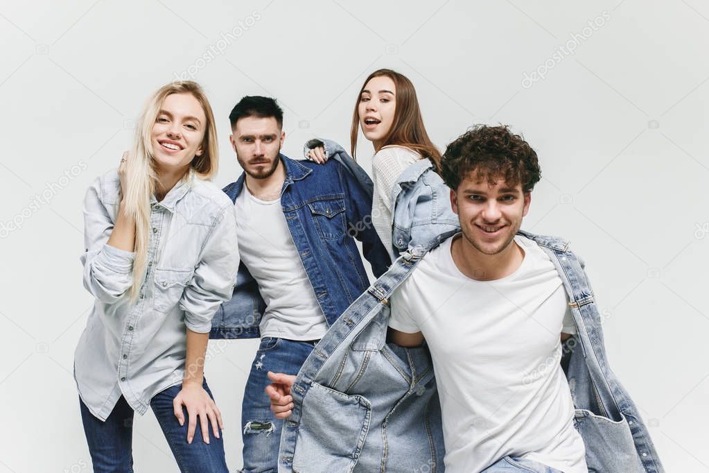 Group of smiling friends in fashionable jeans