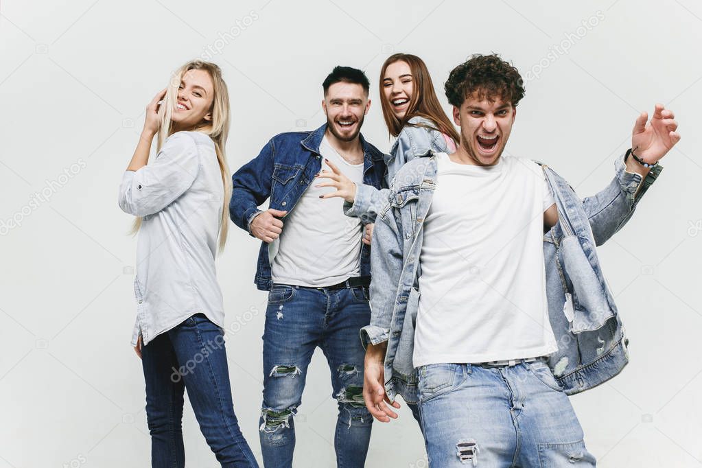 Group of smiling friends in fashionable jeans