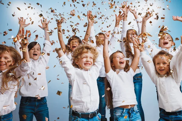 Entzückende Kinder haben Spaß zusammen, werfen buntes Konfetti, — Stockfoto