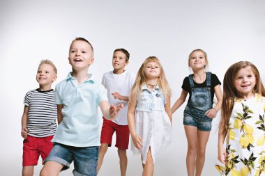 Birlikte poz ve kamera beyaz arka plan arayan arkadaşlar grup moda şirin okul öncesi çocuklar