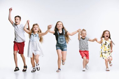 Birlikte poz ve kamera beyaz arka plan arayan arkadaşlar grup moda şirin okul öncesi çocuklar