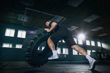 Gömleksiz adam ağır lastik spor salonunda saygısız