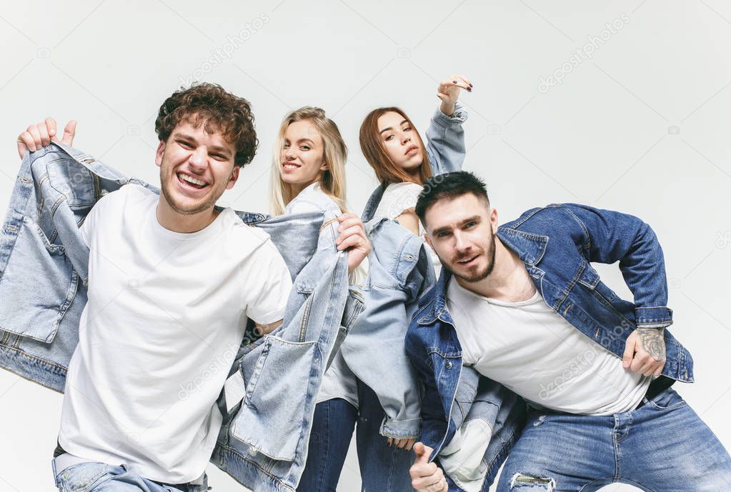 Group of smiling friends in fashionable jeans