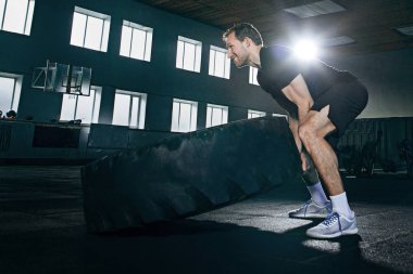 Gömleksiz adam ağır lastik spor salonunda saygısız