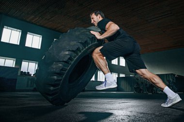 Gömleksiz adam ağır lastik spor salonunda saygısız