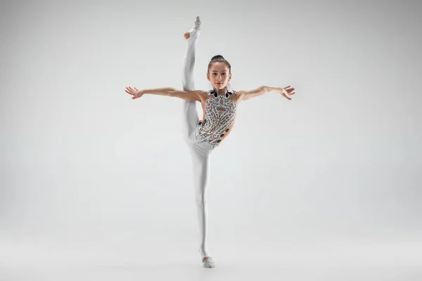 Дівчина-підліток робить гімнастичні вправи ізольовані на білому тлі — стокове фото
