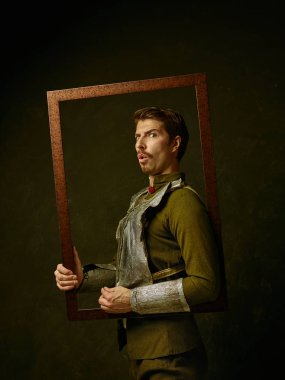 Ortaçağ knight dark studio arka plan üzerinde. Düşük anahtar-in tradishional retro kostüm İspanyol hidalgo, acımasız adam portresi. İnsan duyguları, dönemler ve yüz ifadeleri kavramı karşılaştırılması