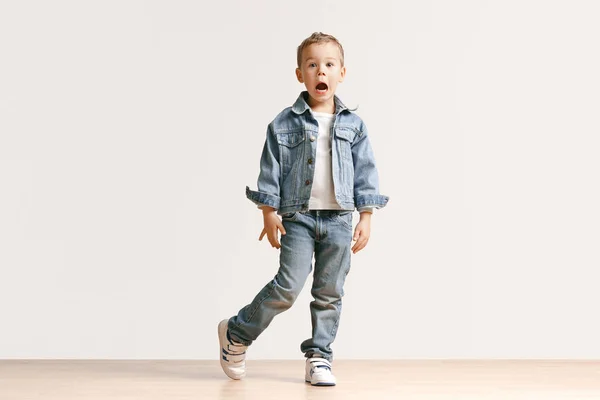 Porträttet av söt liten pojke i snygga jeans kläder tittar kameran på studio — Stockfoto