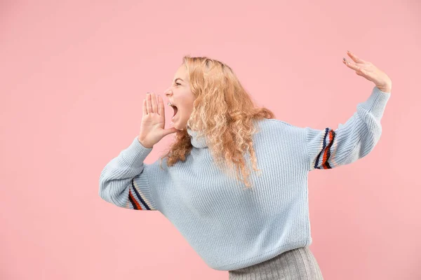 Geïsoleerd op roze jonge casual vrouw schreeuwen in studio — Stockfoto