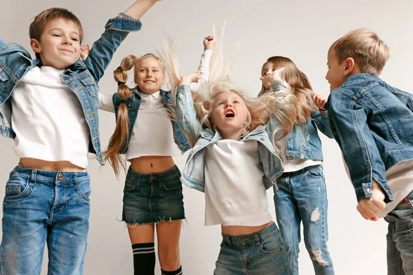 Le portrait de mignon petit garçon et les filles en jeans élégants vêtements regardant la caméra au studio — Photo