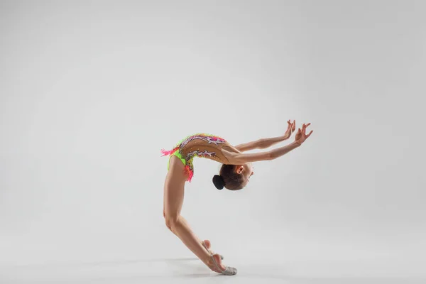 Дівчина-підліток робить гімнастичні вправи ізольовані на білому тлі — стокове фото
