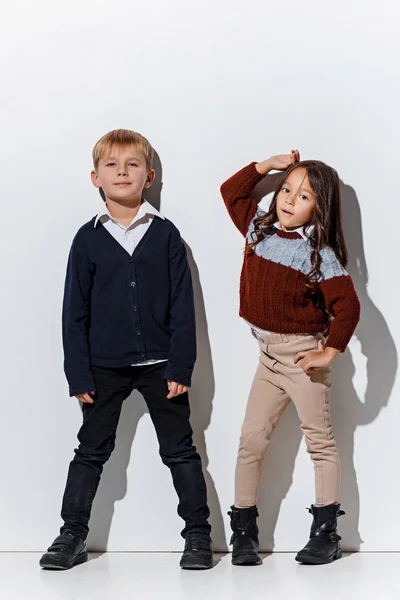 Portret ładny mały chłopiec i dziewczynka w ubrania stylowe dżinsy, patrząc na kamery w studio — Zdjęcie stockowe