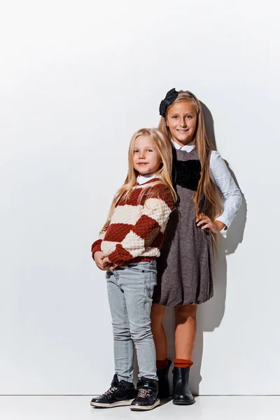 Porträttet av söta små flickor i snygga jeans kläder tittar kameran på studio — Stockfoto