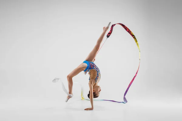 ホワイト スタジオの背景に青いリボンと美しい若いブルネットの女性体操選手トレーニング Calilisthenics の肖像画の練習します 芸術体操のコンセプトです 完全な高さでコーカサス地方モデル — ストック写真