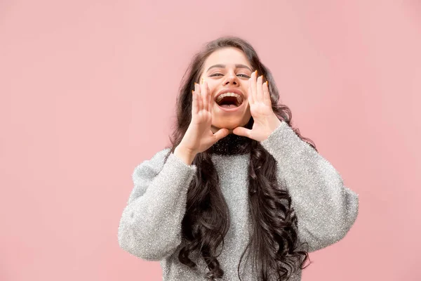 Isolated on pink young casual woman shouting at studio — Stock Photo, Image