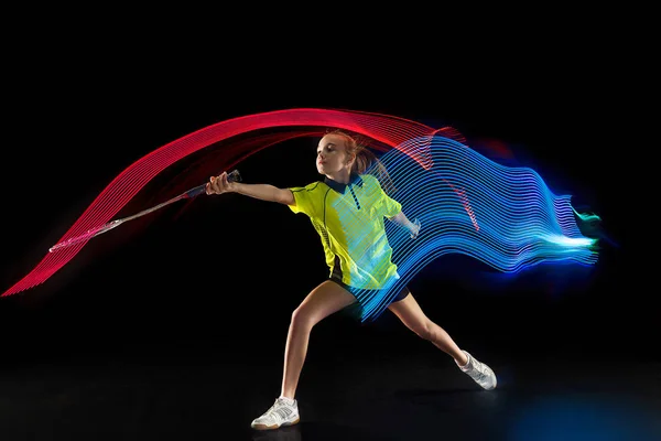 Eine kaukasische junge Teenager Mädchen Frau spielt Badminton-Spieler auf schwarzem Hintergrund — Stockfoto
