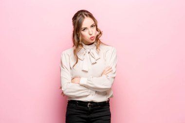 Pembe bir arka plan üzerinde ciddi hayal kırıklığına uğramış genç güzel iş kadını