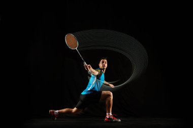 Genç erkek badminton oyuncu balck arka plan üzerine