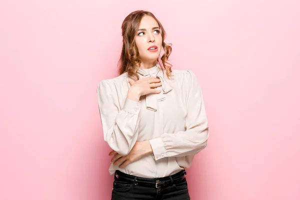 Let me think. Doubtful pensive woman with thoughtful expression making choice against pink background — Stock Photo, Image