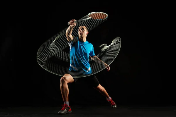 Jeune joueur de badminton masculin sur fond rouge — Photo