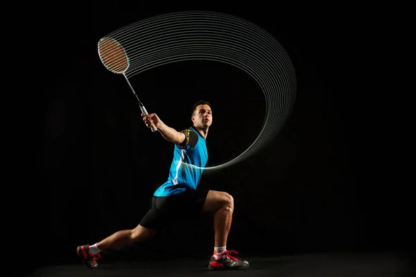 Unga manliga badmintonspelare över balck bakgrund — Stockfoto
