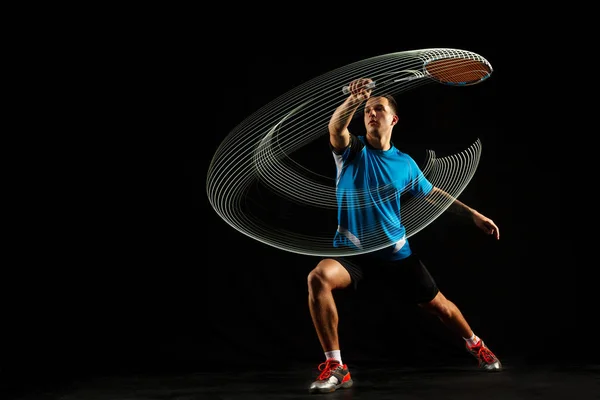 Jeune joueur de badminton masculin sur fond rouge — Photo