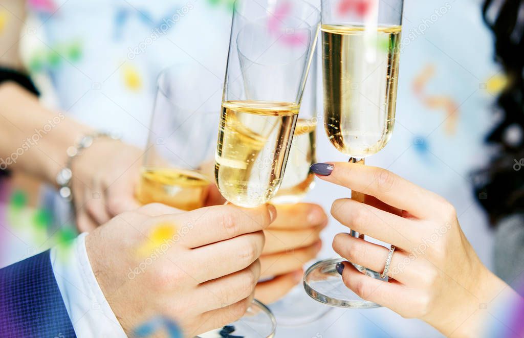 Celebration. Hands holding the glasses of champagne and wine making a toast.