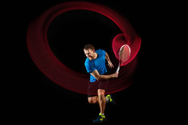 Un hombre caucásico jugando al tenis sobre fondo negro —  Fotos de Stock