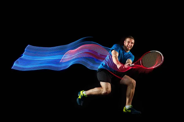 En kaukasisk man spelar tennisspelare på svart bakgrund — Stockfoto