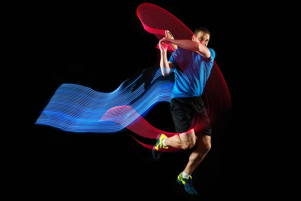 Un hombre caucásico jugando al tenis sobre fondo negro —  Fotos de Stock