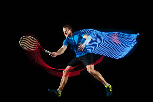 Un hombre caucásico jugando al tenis sobre fondo negro — Foto de Stock