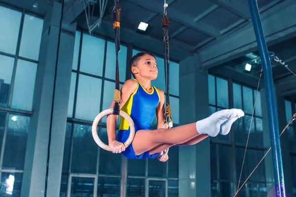 Full length rearview shot of a male athlete performing pull-ups on gymnastic rings. — Stock Photo, Image