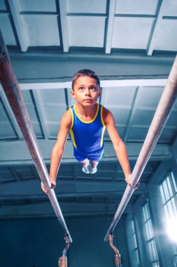 güzel çocuk spor jimnastik paralel bar üzerinde çalışmaktadır