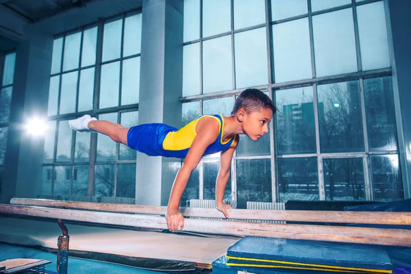 Klučina se zabývá sportovní gymnastikou na rovnoběžné pásy — Stock fotografie