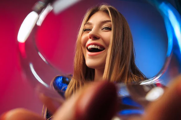 Překvapen, mladá žena v slavnostní oděv pózuje s sklenku vína. — Stock fotografie