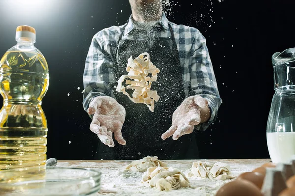 Profissional cozinheiro macho polvilha massa com farinha, preapares ou assar pão na mesa da cozinha — Fotografia de Stock