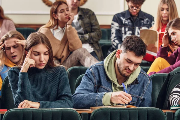 Grupa studentów na szczęśliwy wesoły siedzi w sali wykładowej przed lekcją — Zdjęcie stockowe