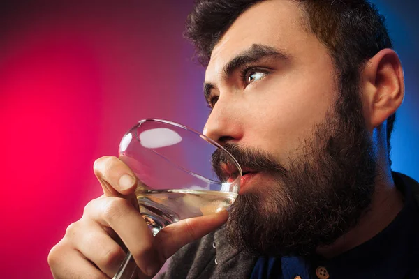 El joven sorprendido posando con una copa de vino . — Foto de Stock