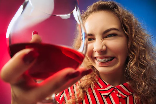 De trieste jonge vrouw in partij kleding poseren met glas wijn. — Stockfoto