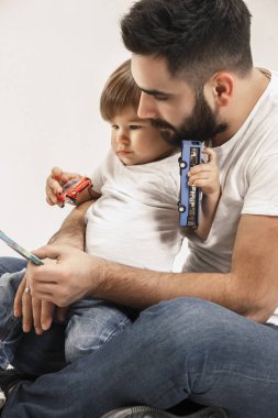 mutlu bir aile ile birlikte oturan ve üzerinde beyaz izole kamera gülümseyen çocuk