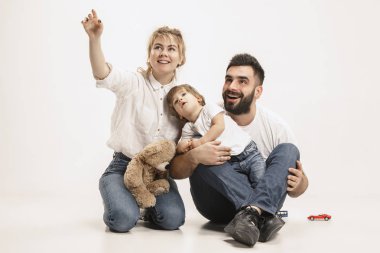 mutlu bir aile ile birlikte oturan ve üzerinde beyaz izole kamera gülümseyen çocuk