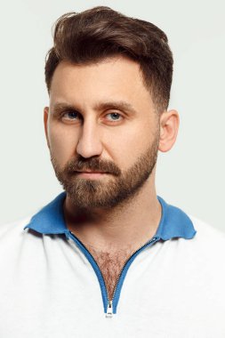 Ayakta ve kamera beyaz arka plan bakarak ciddi adam.