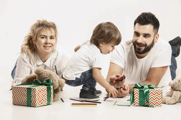 Çocukla birlikte ve üzerinde beyaz izole kamera gülümseyerek mutlu bir aile — Stok fotoğraf