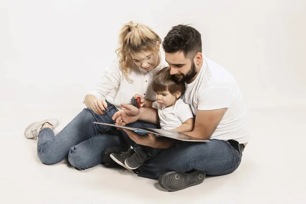 Familia feliz con el niño sentado juntos y sonriendo a la cámara aislado en blanco — Foto de Stock