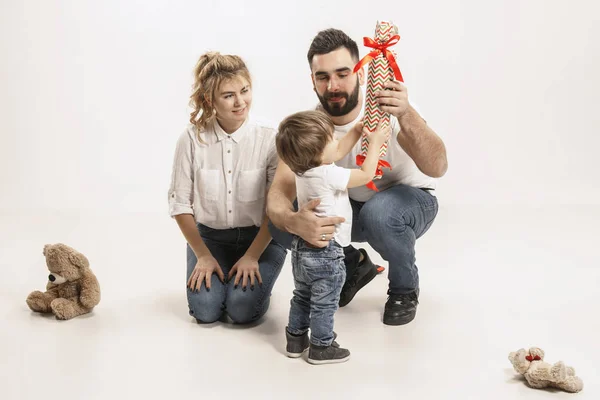 Famille heureuse avec enfant assis ensemble et souriant à la caméra isolé sur blanc — Photo