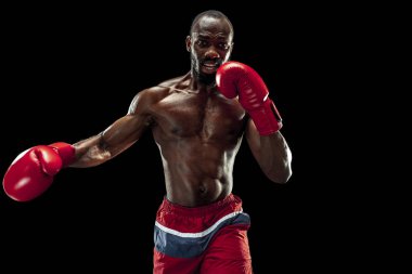 El boksör siyah arka plan üzerinde. Güç, saldırı ve hareket kavramı
